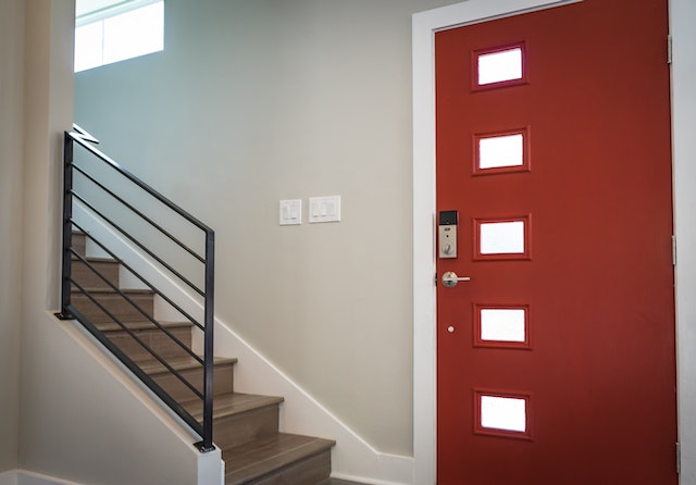 red front door of apartment in front of staircase