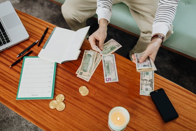 person counting cash on a table