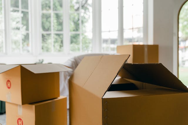 moving boxes in a living room with many windows