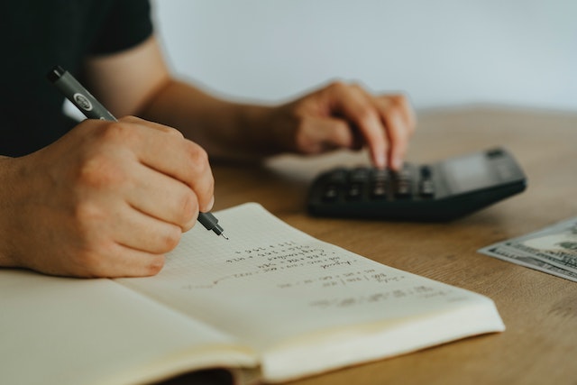 person with a notebook and calculator